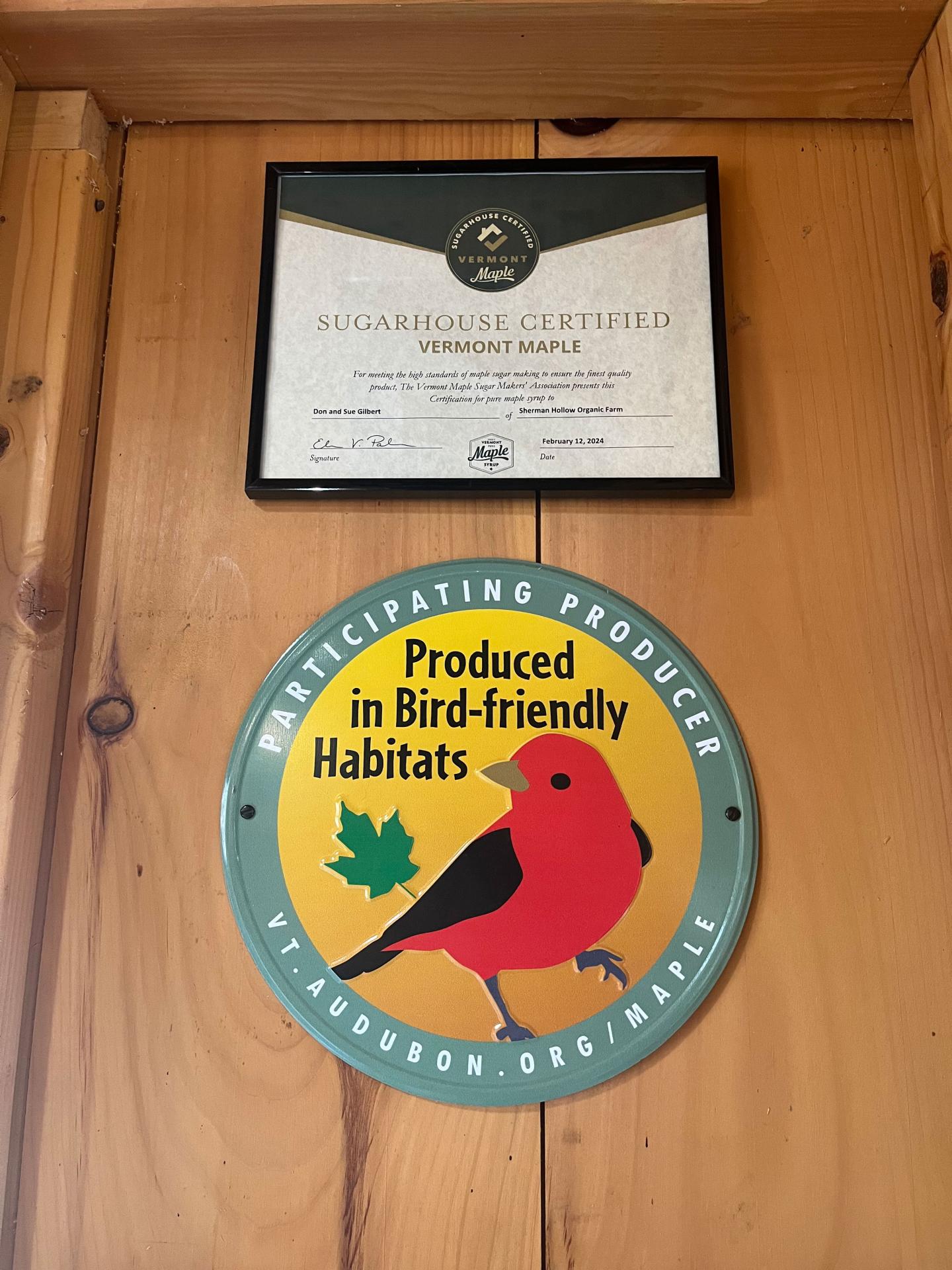 Certificate and bird-friendly logo on wooden wall.