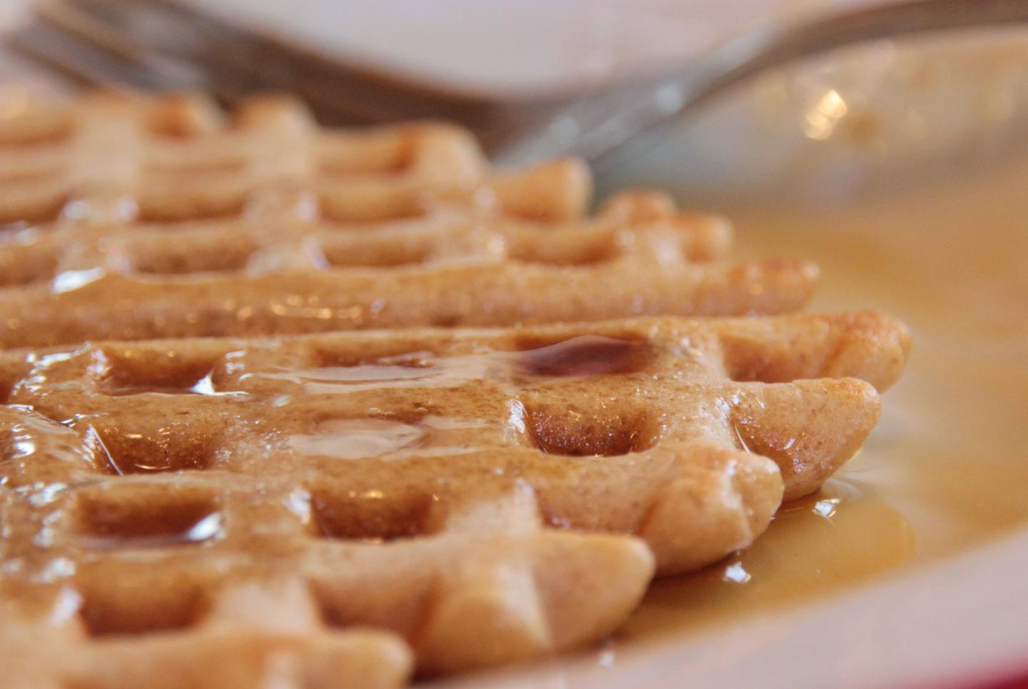 Waffle with syrup and fork on a plate.