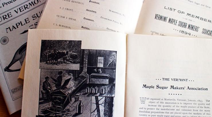 Old newsletters and brochures spread on a table.