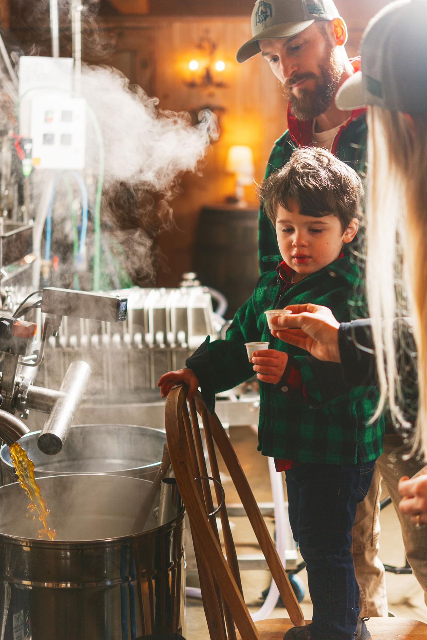 Family observing a steaming brewery process.