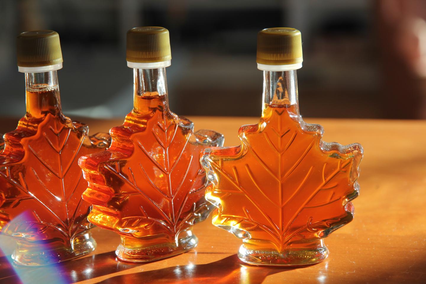 Maple leaf-shaped bottles filled with amber liquid.
