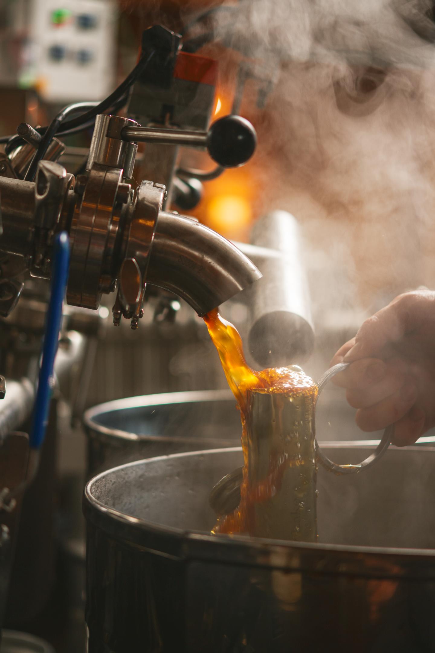 Steaming liquid poured from spout into mug.