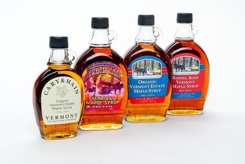 Four bottles of Vermont maple syrup on a white background.