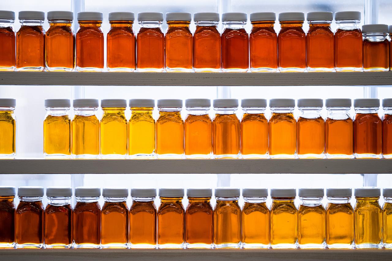 Rows of amber glass bottles with white caps on shelves.
