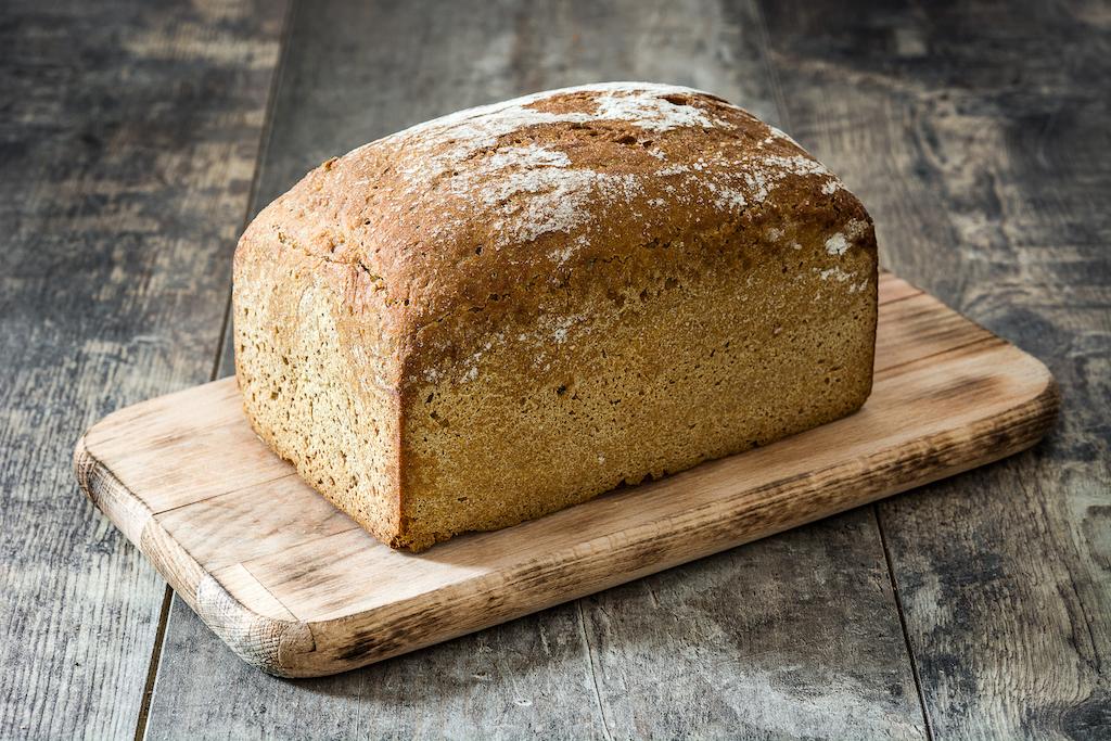 Whole wheat bread loaf on a wooden board.