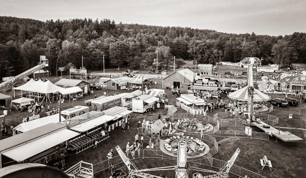 Black-and-white aerial view of a rural fairground.